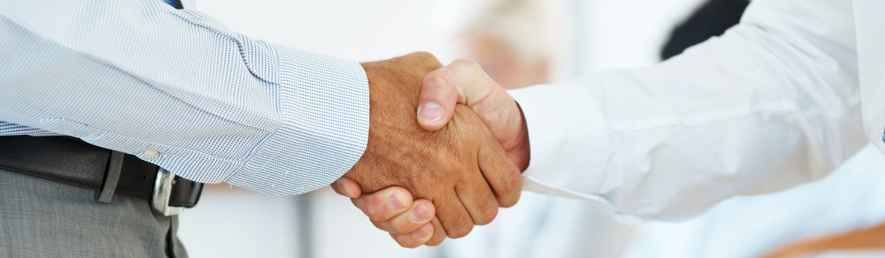 Two business man shaking their hands in office – Corporate deal